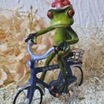 GLF2009 Gl&uuml;cksfrosch Fahrradfahrer mit blauem Fahrrad und gro&szlig;em Bollenhut