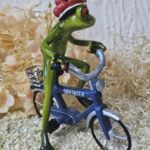 GLF2009 Gl&uuml;cksfrosch Fahrradfahrer mit blauem Fahrrad und gro&szlig;em Bollenhut