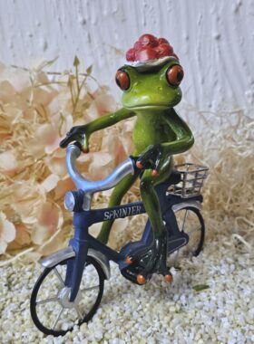 Glücksfrosch Fahrradfahrer mit blauem Fahrrad und großem Bollenhut